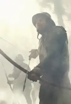 Daryl Dixon with bow and arrow in fog