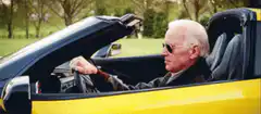 Old man driving a yellow convertible