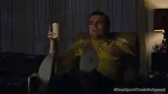 Rick Dalton pointing with a drink