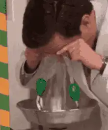man points at green spots on plastic bag