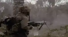 Soldier firing machine gun in forest