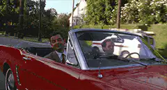 Mr. Bean waving at a police car