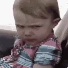 Toddler eating with a disgusted face