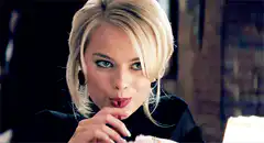 Margot Robbie smirking and licking lips