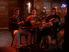 Three men sitting at a table in a bar