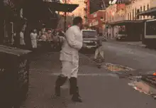 Man in white coat dancing on street
