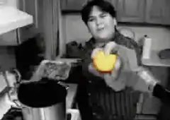 man adds tomato to pot