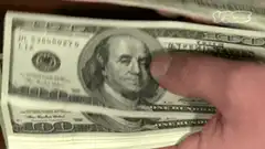 finger poking benjamin franklin on hundred dollar bill
