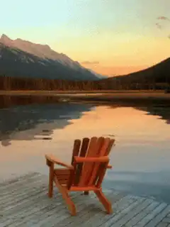 wooden chair on dock at sunset