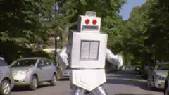 Silver robot dancing on a suburban street