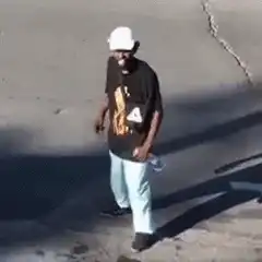 Man in white hat dancing on street