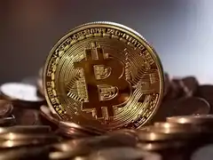 Gold Bitcoin coin on pile of coins