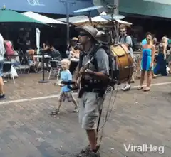 Man playing backpack drum kit on street