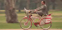 Man riding a red bicycle with a megaphone