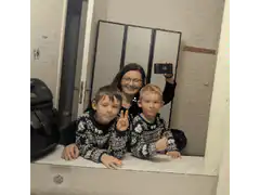 Woman and two boys making peace signs in mirror
