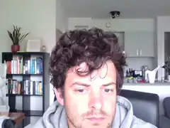 Man with curly hair looking at camera