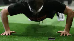 man doing pushups on green turf