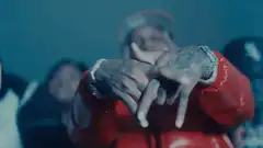 Tattooed hands making hand sign