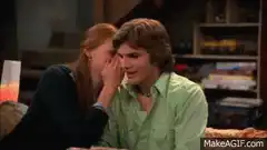 Woman whispers to man who reacts with shock