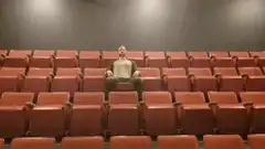 Man clapping in empty theater
