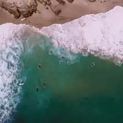 aerial view of surfers in ocean waves