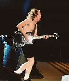 Angus Young playing guitar on stage