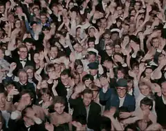 The Beatles waving to a crowd