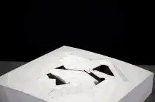 person assembling broken white sculpture