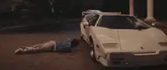 Man lying next to white Lamborghini