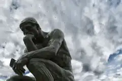The Thinker statue against cloudy sky