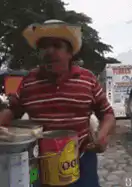 Man playing cans with drumsticks