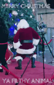 Santa dancing in front of Christmas tree