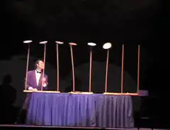 Magician catches plates on sticks
