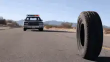 police car chasing rolling tire