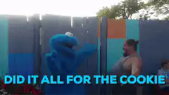 Cookie Monster hugs man