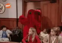 Red monsters dancing in a classroom