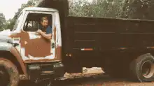 Man in rusty truck waves