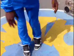 Man in blue tracksuit dancing on playground