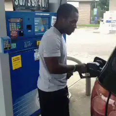 Man dancing while pumping gas