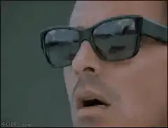 Man lifts sunglasses in shock