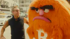 Oscar the Grouch hugs a man
