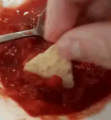 dipping tortilla chip in salsa