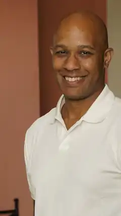 Smiling bald man in white polo