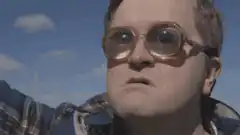 Man in sunglasses looking up in shock