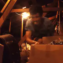 Man frantically packing boxes in attic