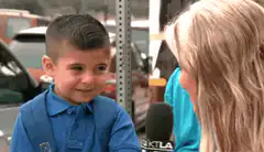 Boy covers face during interview
