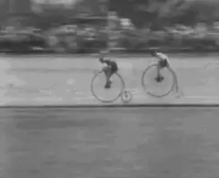 Two men racing on penny-farthing bicycles