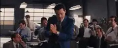 Jordan Belfort smiling and laughing in the office