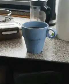 Hand picks up blue coffee mug