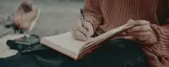 person writing in a notebook